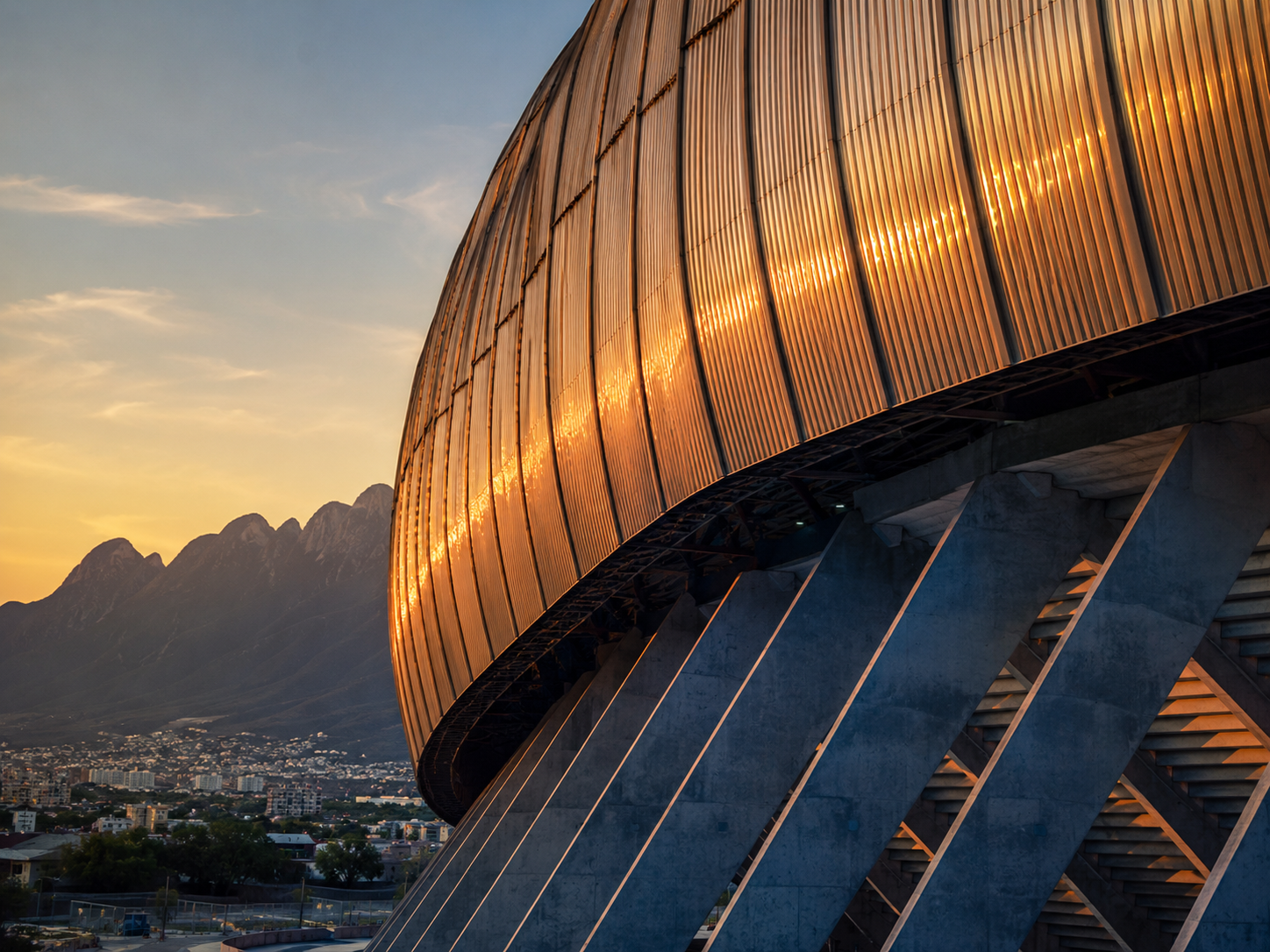 Estadio BBVA's corrugated steel façade and asymmetrical armadillo-shell roof at sunset.