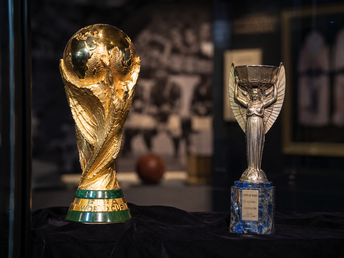 Historic FIFA World Cup and Jules Rimet trophy comparison in a museum setting.