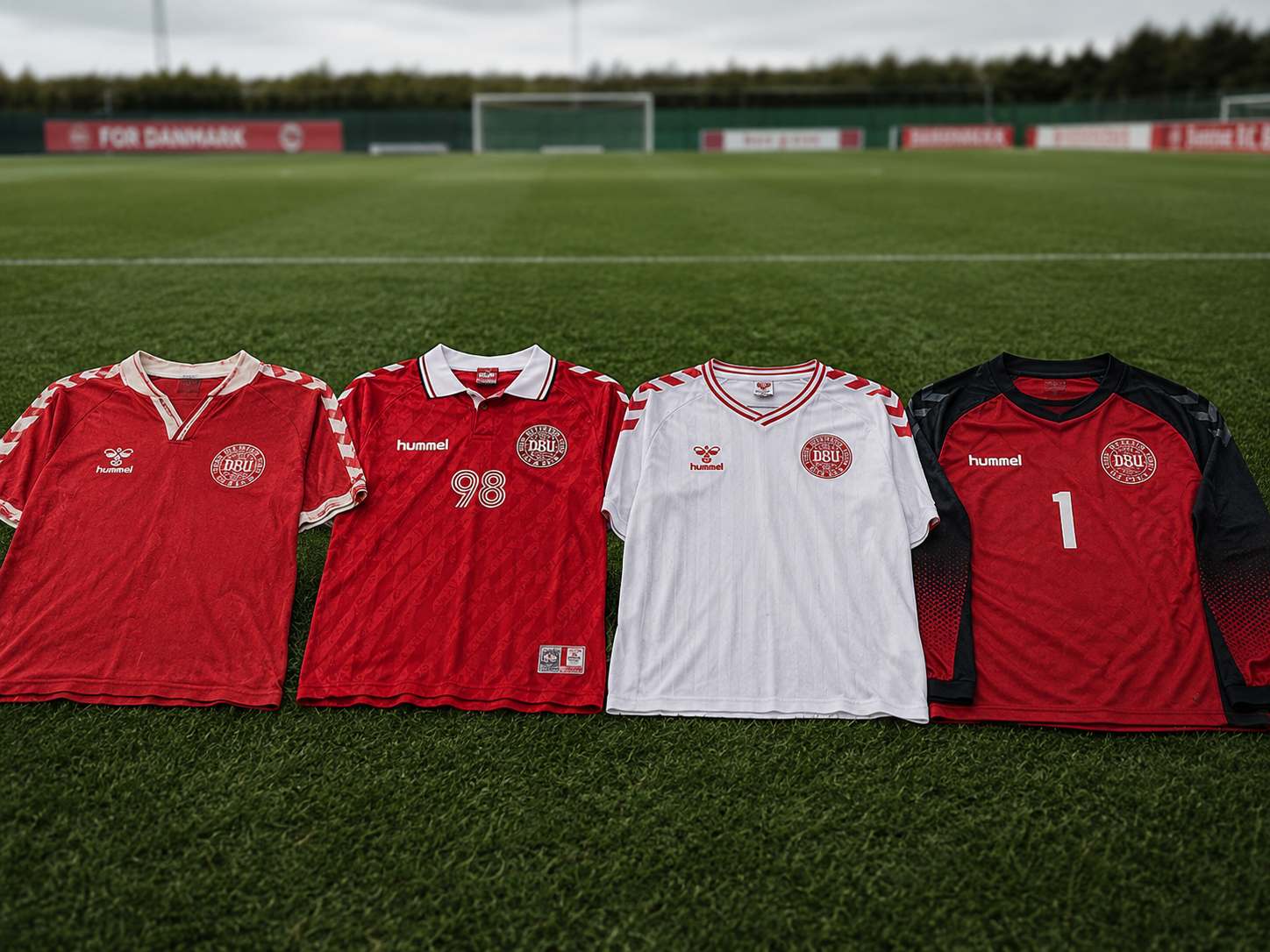 Four iconic Denmark national team soccer jerseys on a pitch.